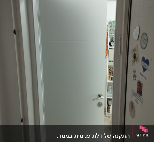 דלת לבנה פתוחה עם ידית כסופה